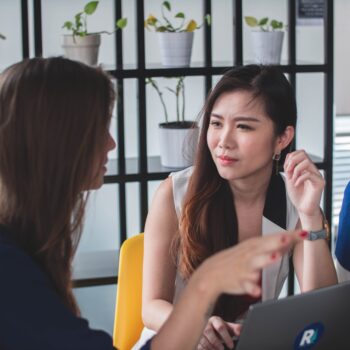 women talking at a laptop