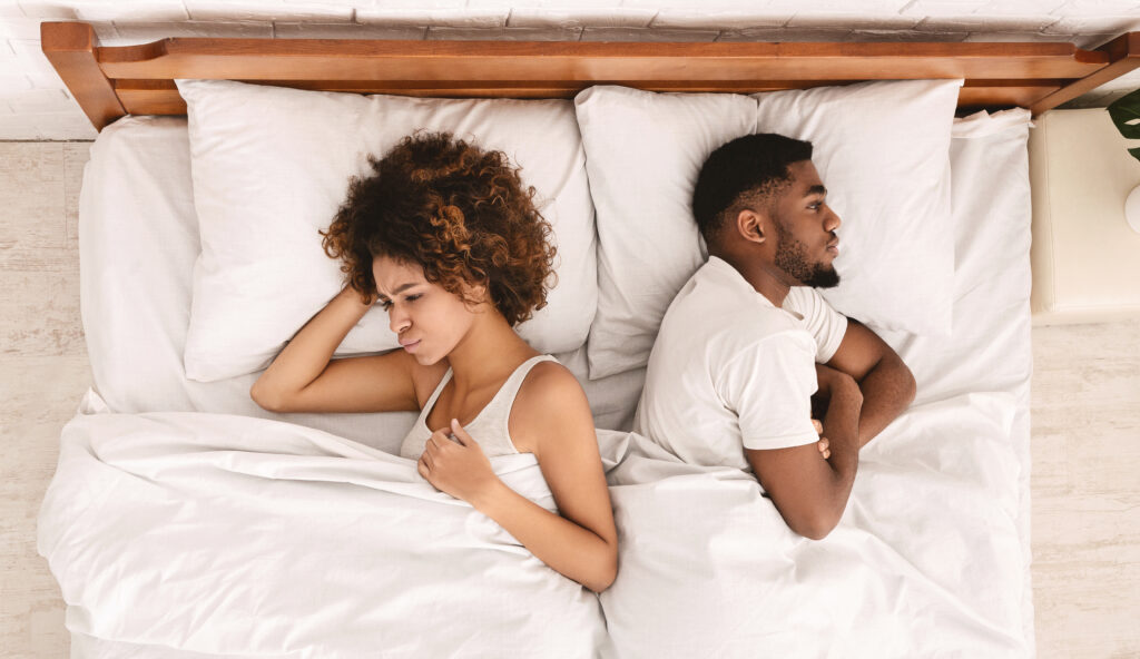 couple ignoring each other in bed