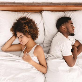 couple ignoring each other in bed