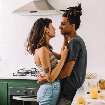 Young couple hugging in kitchen