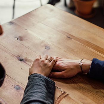 couple holding hands on the table