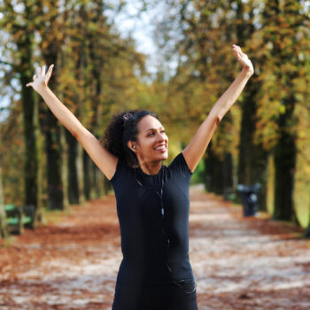 positive middle aged woman stretching outdoors preparing for exercise