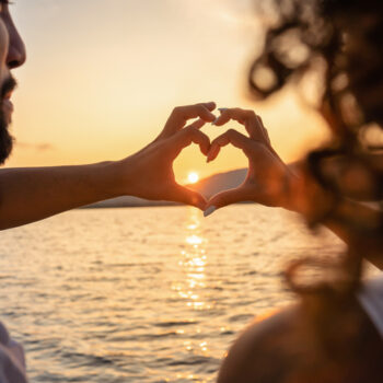 young beautiful couple doing heart shape with fingers